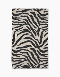 The Geometry Zira Black rug is a rectangular piece featuring bold black and white zebra stripes, crafted from recycled materials and displayed flat against a white background.