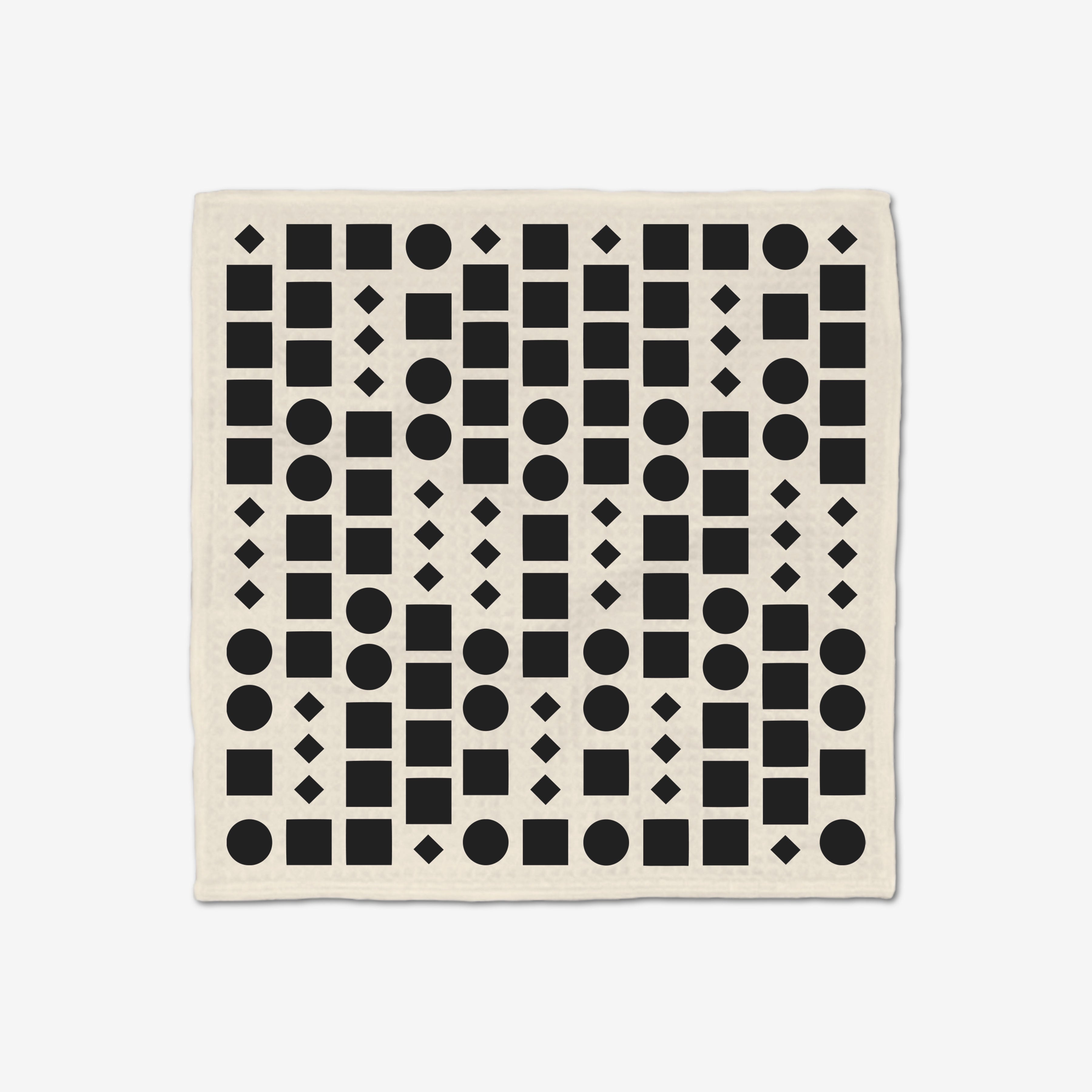 The GEOMETRY Coded Luxe Washcloth is cream-colored and made from post-consumer recycled materials. It features a repeating grid of black circles, squares, and diamonds. Ultra-absorbent and stylish for everyday use.