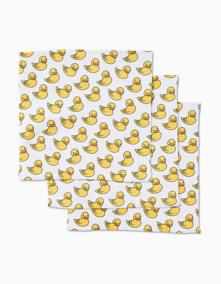 Three GEOMETRY Duckies Luxe Washcloths, made from recycled materials and highly absorbent, display a fun pattern of yellow rubber ducks facing various directions.