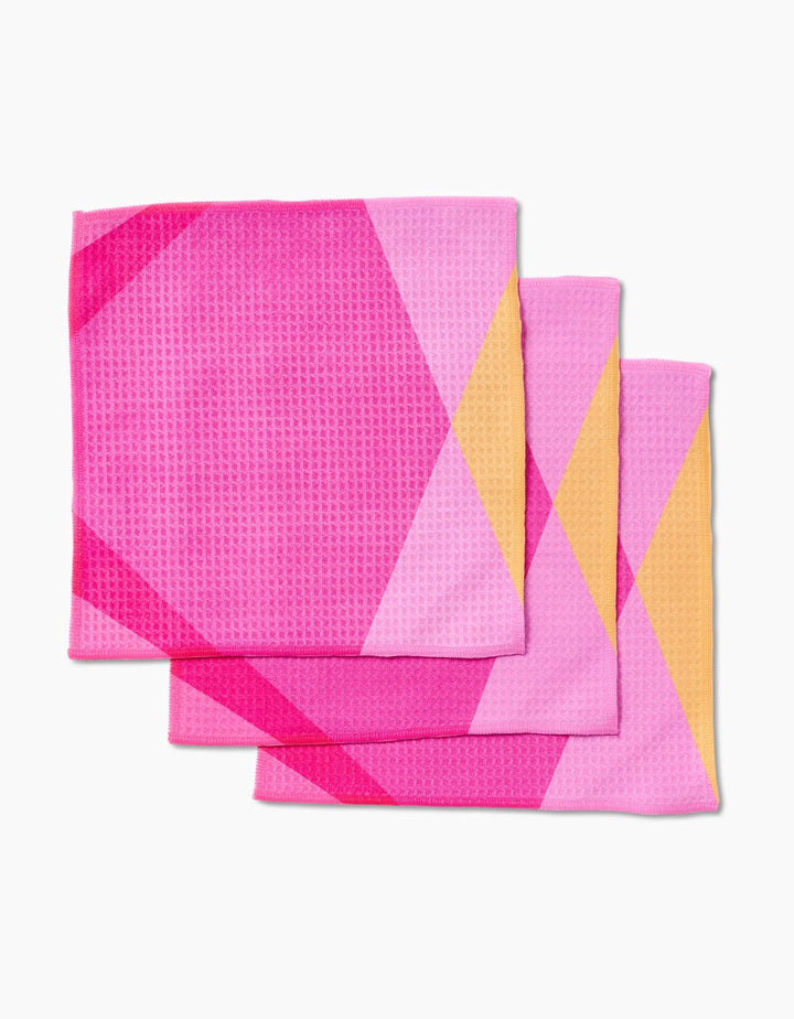 Three GEOMETRY Electric Pink washcloths featuring a geometric pattern in shades of pink, magenta, and yellow are stacked with slight overlap on a white background.