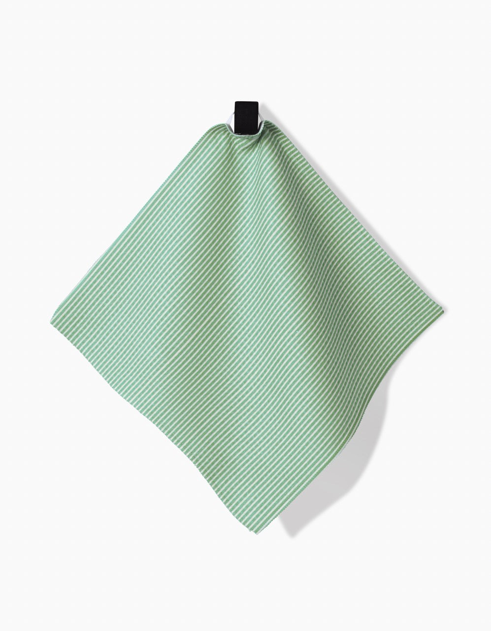 A green and white striped GEOMETRY Half and Half washcloth hangs from a black loop against a white background, featuring ultra-absorbent Geoweave technology.