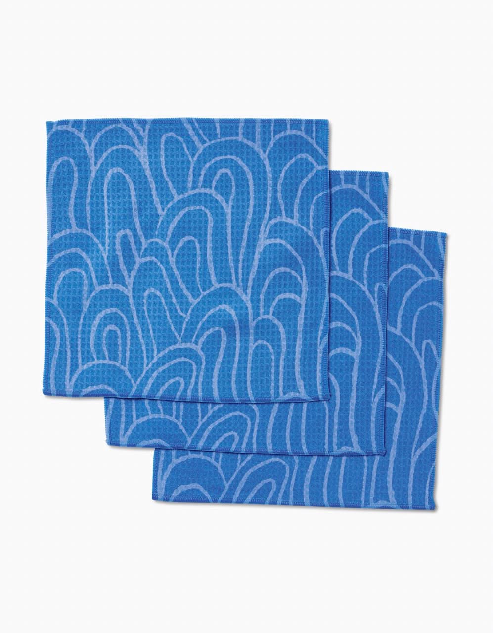 Three High Tide dishcloths by Sareka Unique, featuring a wavy blue pattern and Geoweave technology for superior absorbency, are stacked slightly offset on a white background.