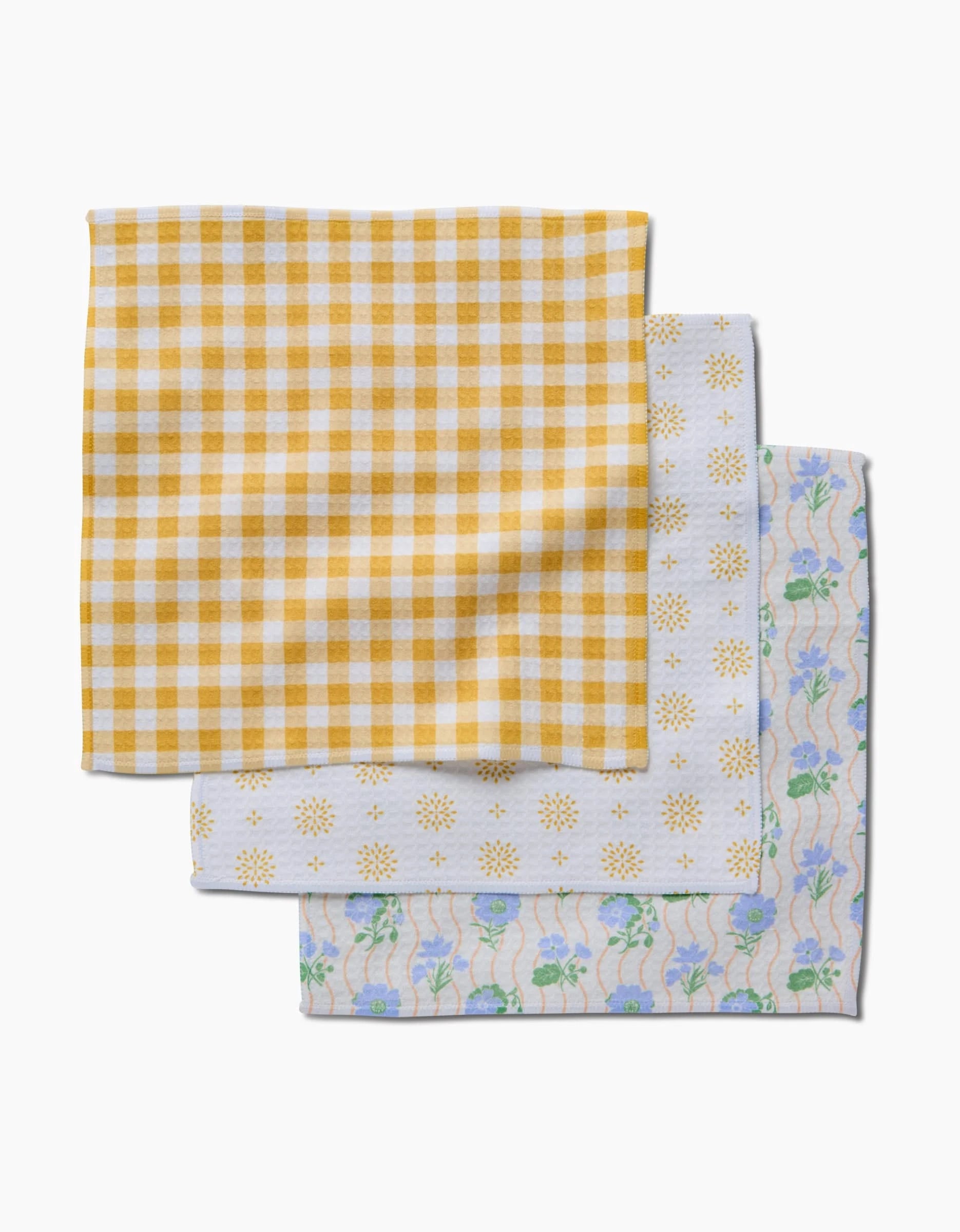 The Danelys Sidron Spring Morning set includes three ultra-absorbent Geoweave napkins: yellow gingham, white with yellow suns, and a floral blue-green design.