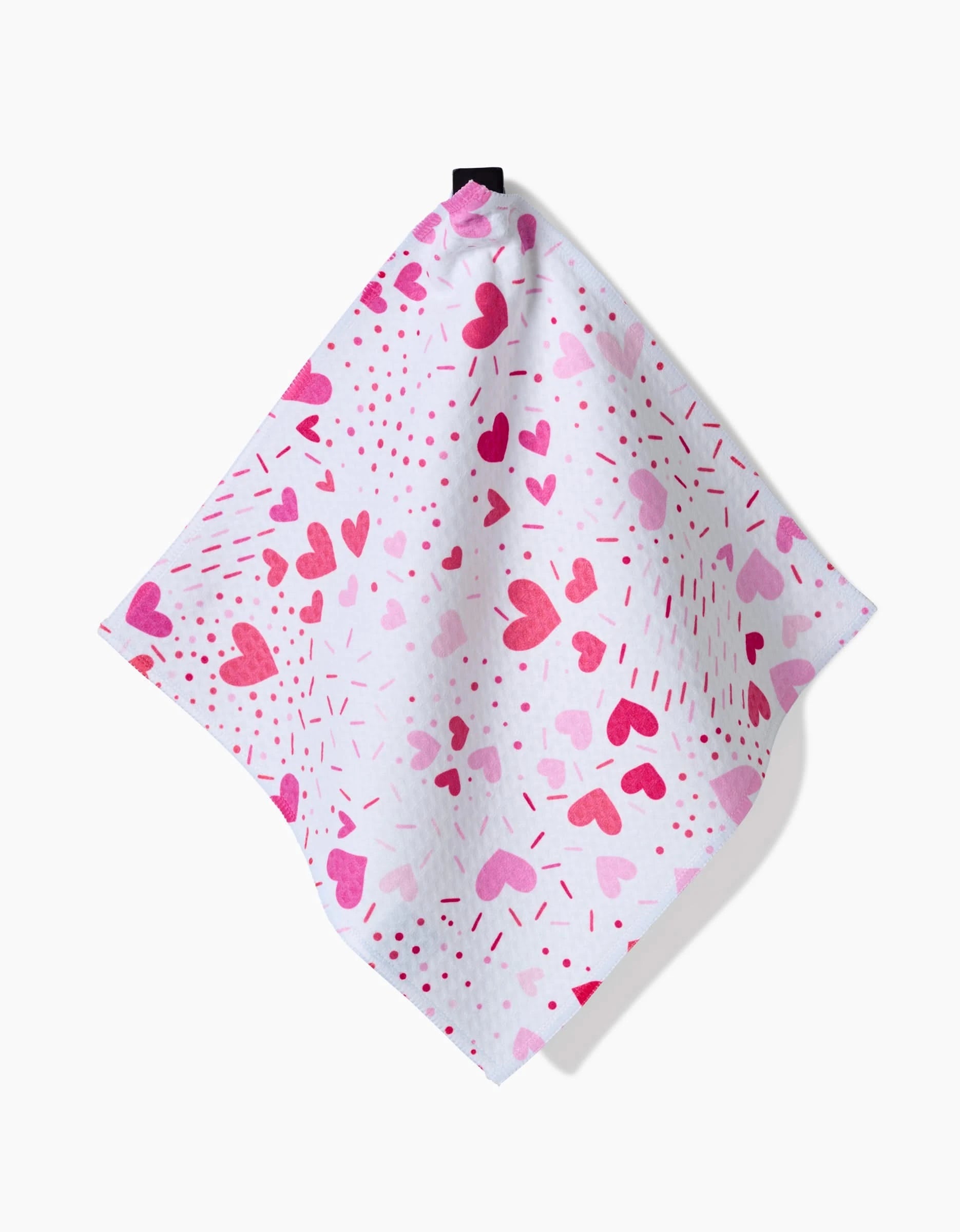 The Sprinkled With Love washcloth by Rebecca Bobko features ultra-absorbent white fabric with pink and red hearts, dots, and dashes, and hangs from a black loop.