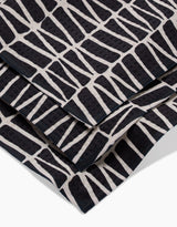 A close-up of Rosa Kichlines Textured Geometry towels—crafted from recycled materials—showcasing a bold black and white abstract pattern of irregular geometric blocks.