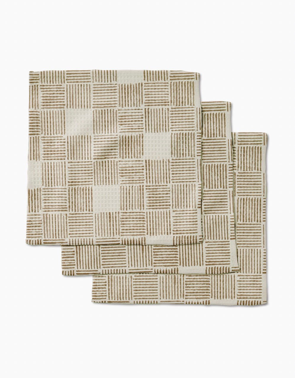 Three Thatcher napkins by Studio Jeannot are stacked on a white background, featuring a beige color and brown grid pattern. Crafted from ultra-absorbent recycled materials, theyre both stylish and eco-friendly.