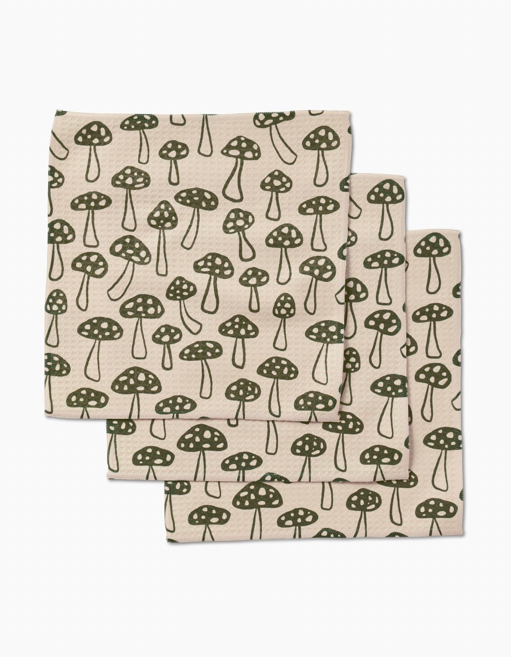 Three ultra-absorbent Kayla Ann Woodland Mushroom washcloths, crafted from post-consumer recycled materials and featuring a repeating green mushroom pattern, are neatly stacked with partial overlap on a white background.