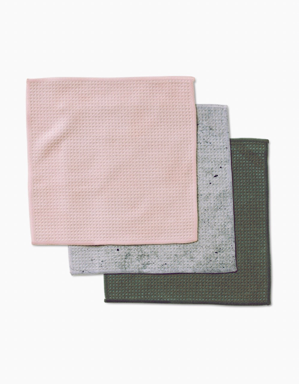 Three square dishcloths from The Wright Set by Kailee Wright—light pink on top, gray in the middle, dark green on the bottom—crafted from Geoweave fabric, are displayed overlapping on a white background.