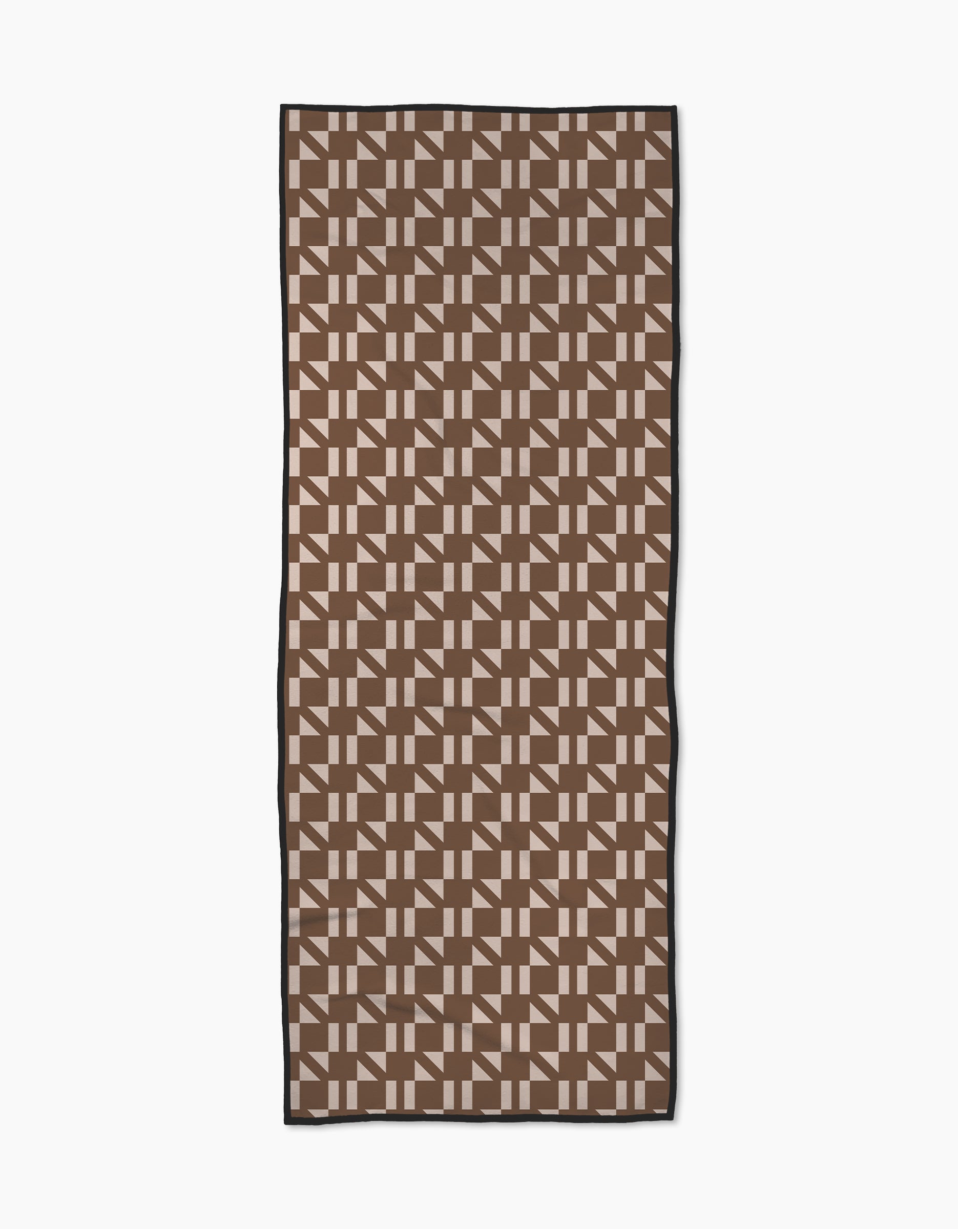 The Geometry Affogato yoga towel features a repeating geometric pattern of interlocking brown and beige shapes, framed by a thin black border. Made from recycled materials, it’s shown on a white background.