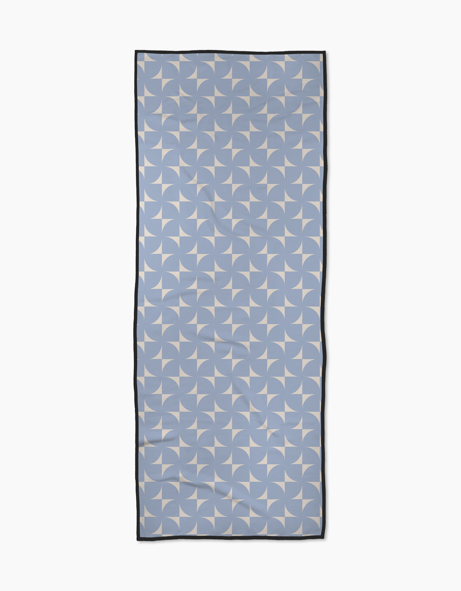 The Airy Flow scarf by Geometry is rectangular and light blue, made from recycled materials with a white geometric pinwheel pattern and thin black border, shown laid flat on a white background.