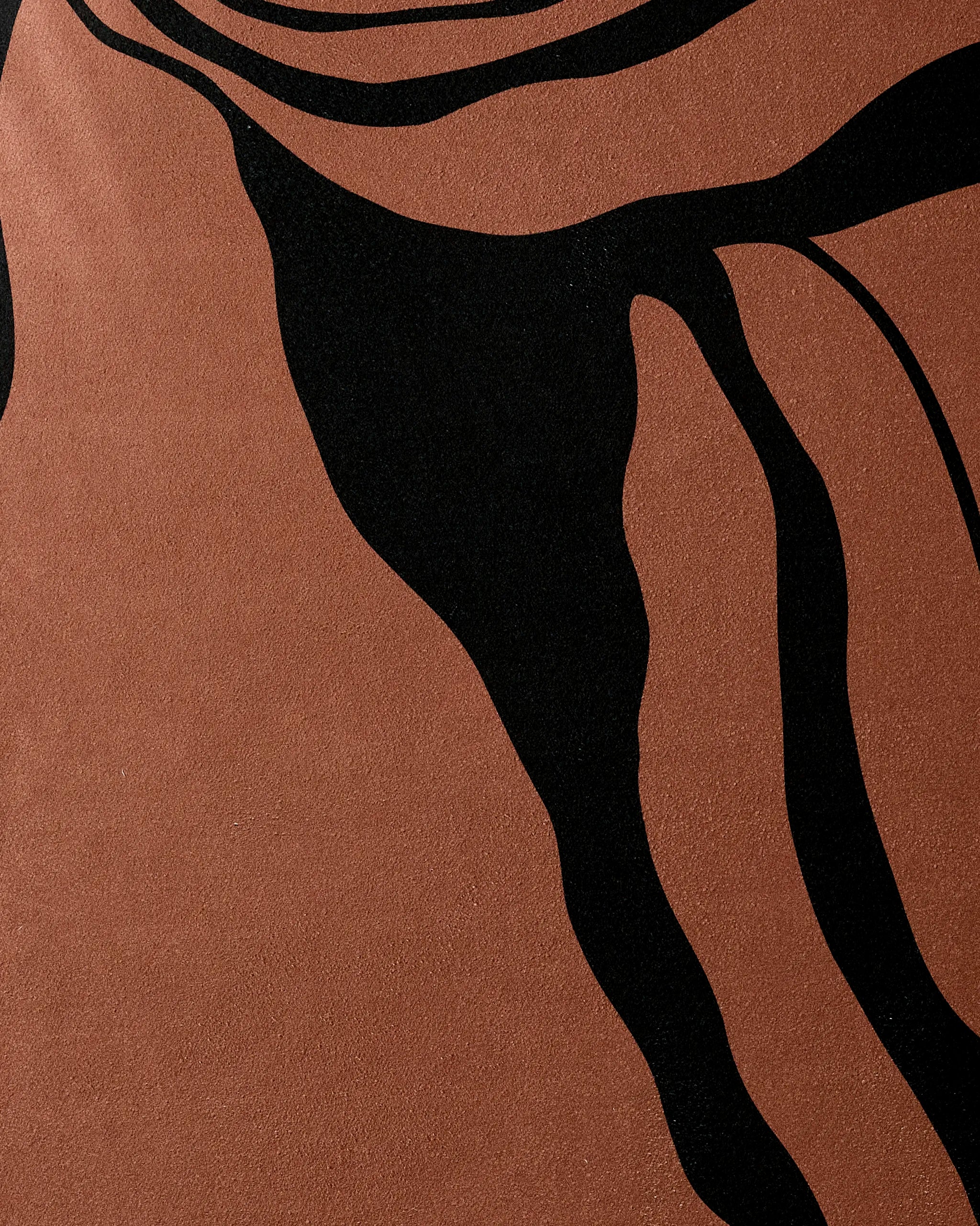 A close-up of the Cole Strem Black Swirl recycled yoga towel shows brown and black wavy lines in an organic, flowing pattern, resembling natural contours for a modern, textured look.