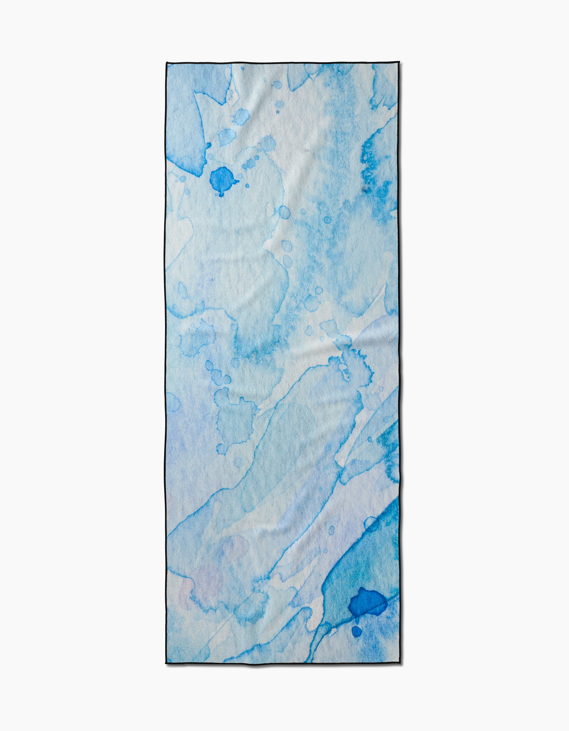 The GEOMETRY Boundless Blue is a rectangular recycled yoga towel featuring abstract watercolor splashes and soft blue brushstrokes on a light background.