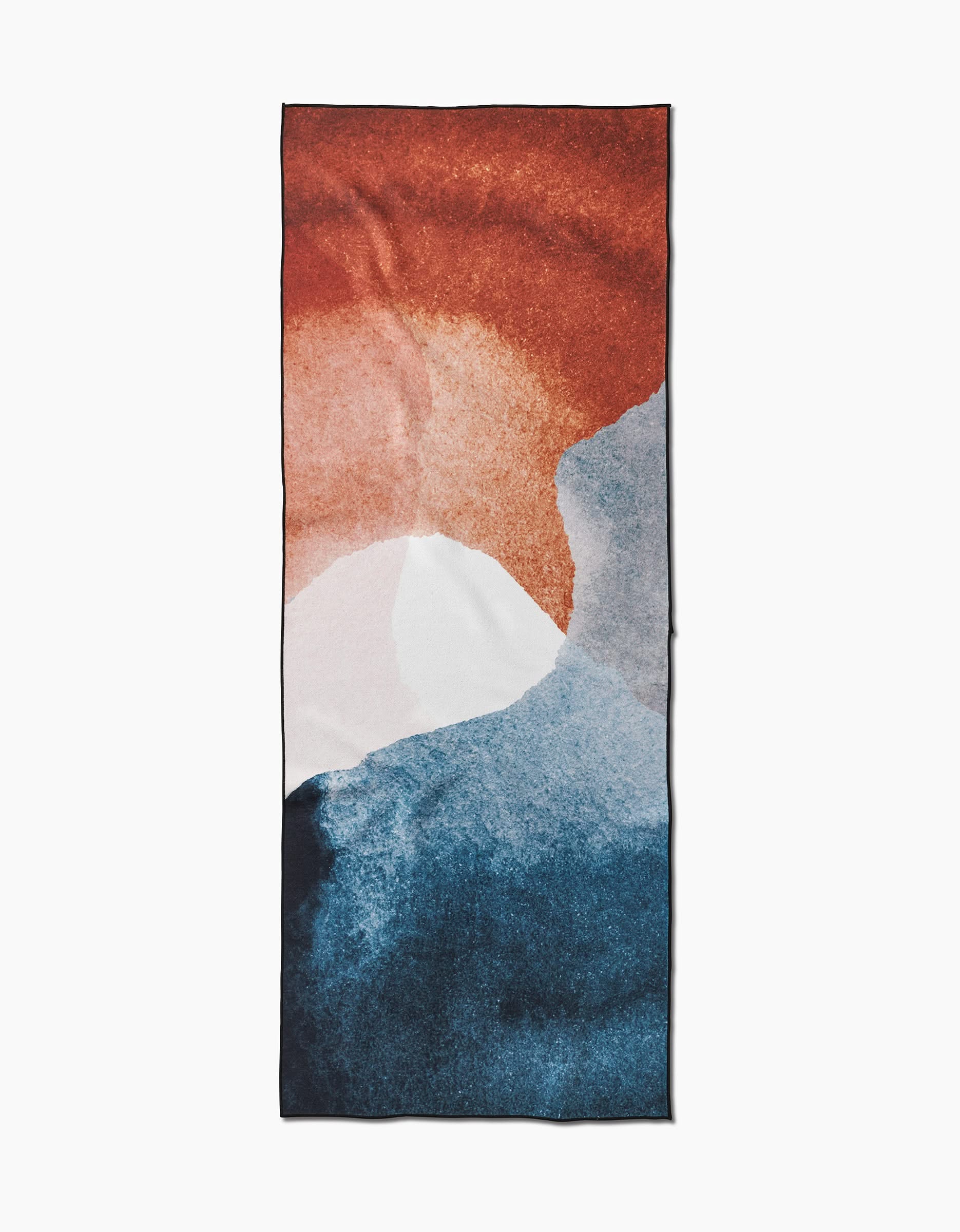 The GEOMETRY Centered yoga towel features a rectangular, slip-resistant design with an abstract rust red, white, and blue sunset pattern on a plain white background.