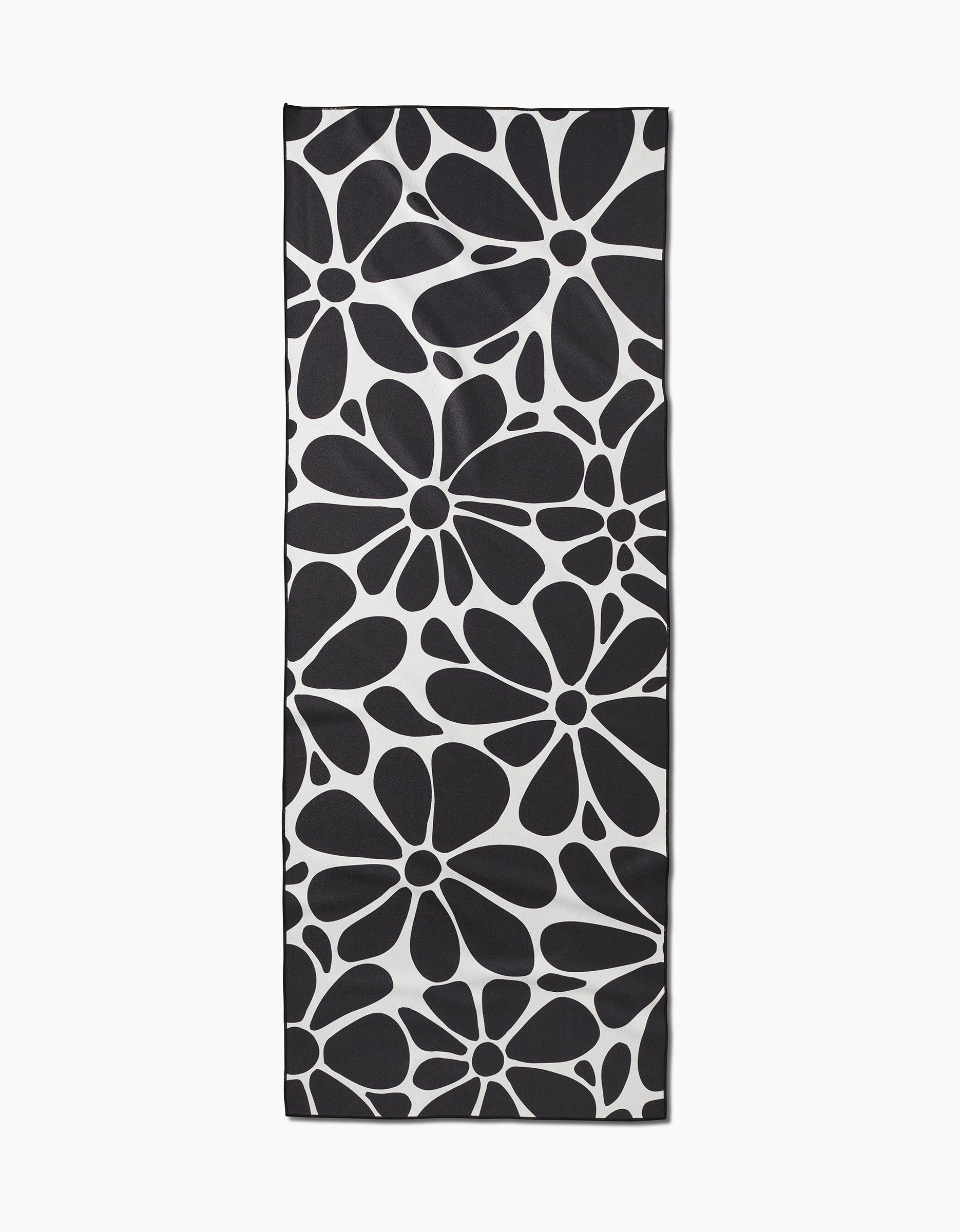 The GEOMETRY Cute Flowers yoga towel features a bold black and white abstract flower pattern on a white background. Made from recycled materials, its perfect for eco-conscious yogis who value style and sustainability.