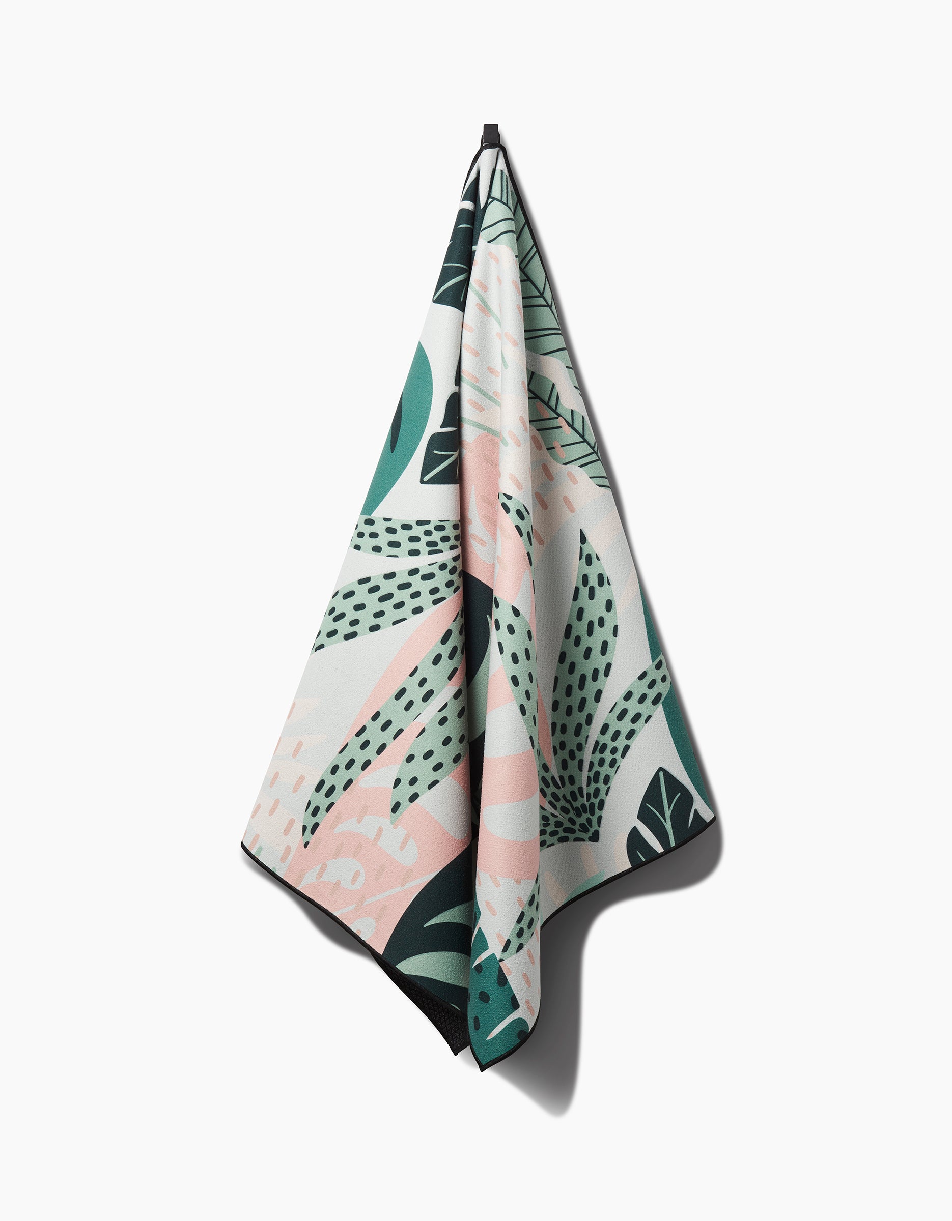The GEOMETRY Diedre is a recycled hanging yoga towel featuring a tropical leaf pattern in green, black, and soft pink, shown against a plain white background.