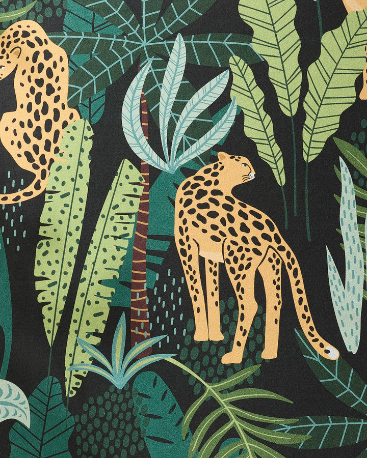 An illustration called "Feeling Spotty" by GEOMETRY shows two cheetahs with yellow fur and black spots among lush green tropical leaves on a dark background, inspired by vibrant yoga towels made from recycled materials.