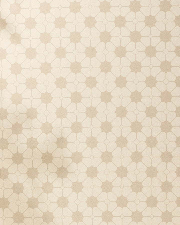 Flora Tile by Geometry features a beige and cream geometric wallpaper with interlocking quatrefoil and star patterns, inspired by the calming symmetry of a yoga towel for a soft, retro-style look.
