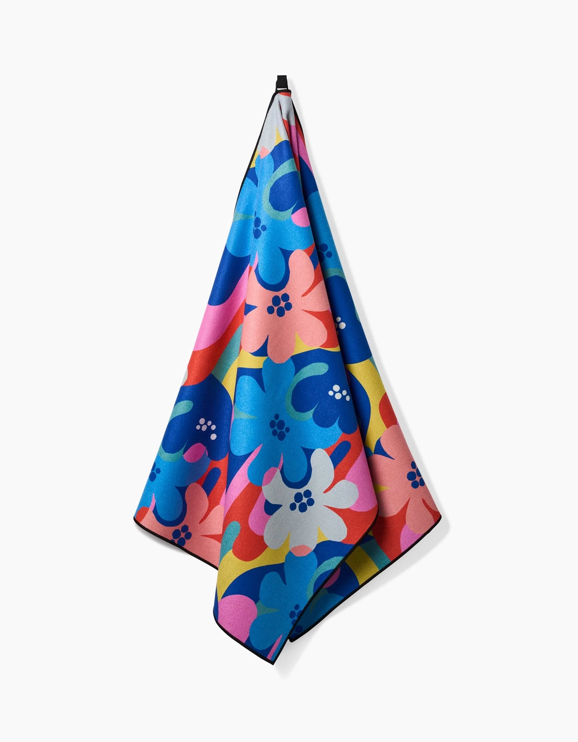 The Flower Powers yoga towel by Masha Volnova features a bold, abstract floral pattern in blue, pink, red, yellow, and white. Made with recycled materials for an eco-friendly touch and shown against a plain white background.