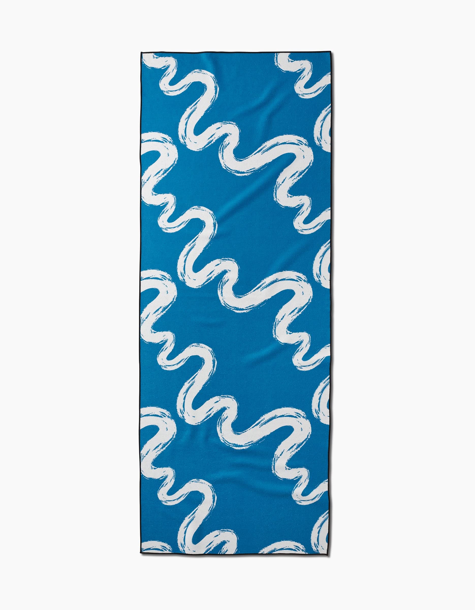 The Elena Fay Go With the Flow yoga towel is rectangular and blue, featuring a stylish white wavy brushstroke pattern for both function and flair during your practice.