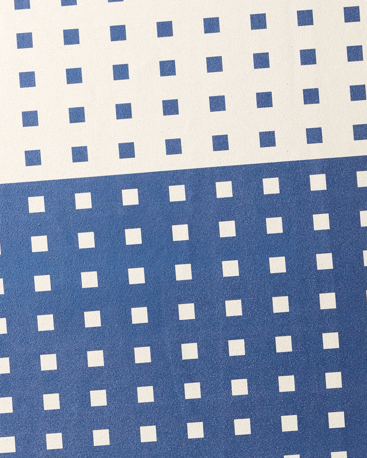 Harmony Haze by Happy Hemera features evenly spaced blue squares on white, with a white top half and a blue lower half accented by white squares—perfect for a stylish, non-slip yoga towel.