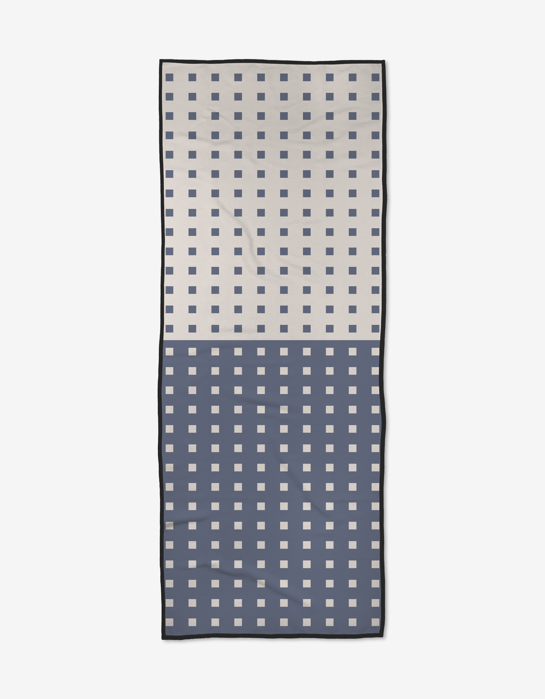 The Harmony Haze yoga towel by Happy Hemera is rectangular, made from recycled materials, and has a grid of small squares—light with dark squares on top, dark with light squares below. It features a black border and a center crease.
