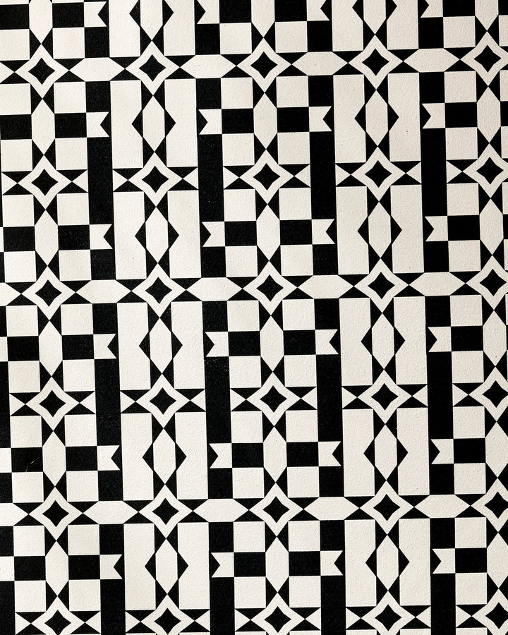 The Intermission yoga towel by Geometry features a black and white geometric pattern of interlocking squares, diamonds, and triangles for a symmetrical optical illusion on recycled material.