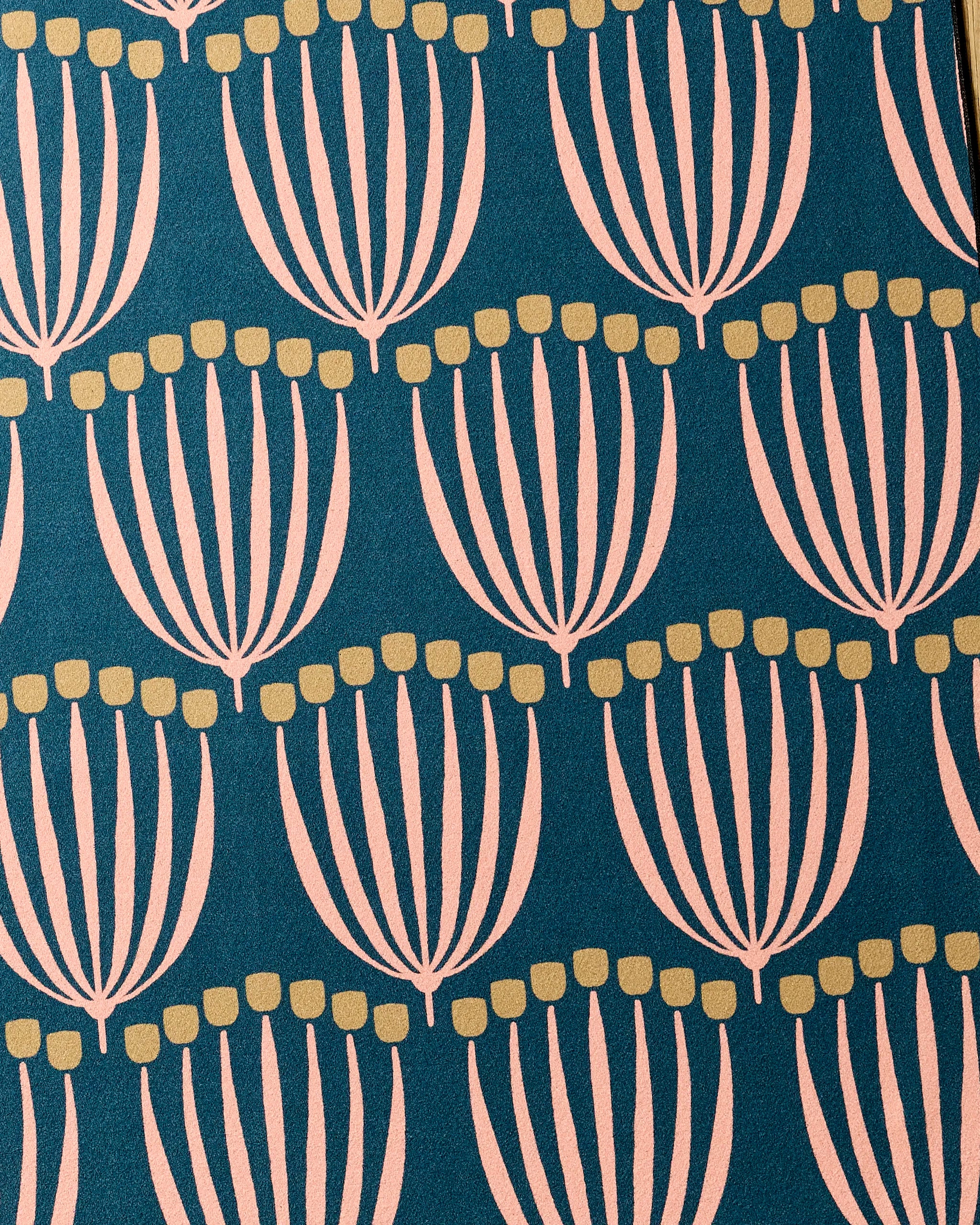 The Josie recycled yoga towel by Amy MacCready features a modern, geometric pattern of stylized pale pink florals with yellow dots on a dark teal background.