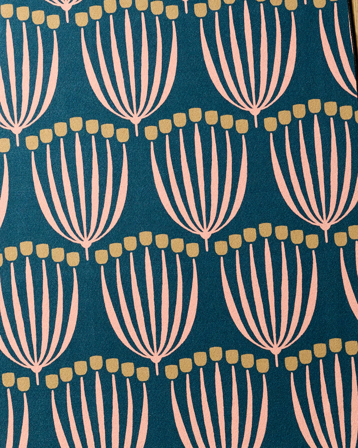 The Josie recycled yoga towel by Amy MacCready features a modern, geometric pattern of stylized pale pink florals with yellow dots on a dark teal background.