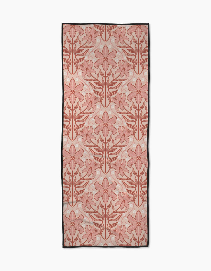 The Lily Nouveau yoga towel by Sarah Daugherty features a recycled, rectangular design with large pink and red floral patterns outlined in red, subtle dot accents on a light background, and a black border.