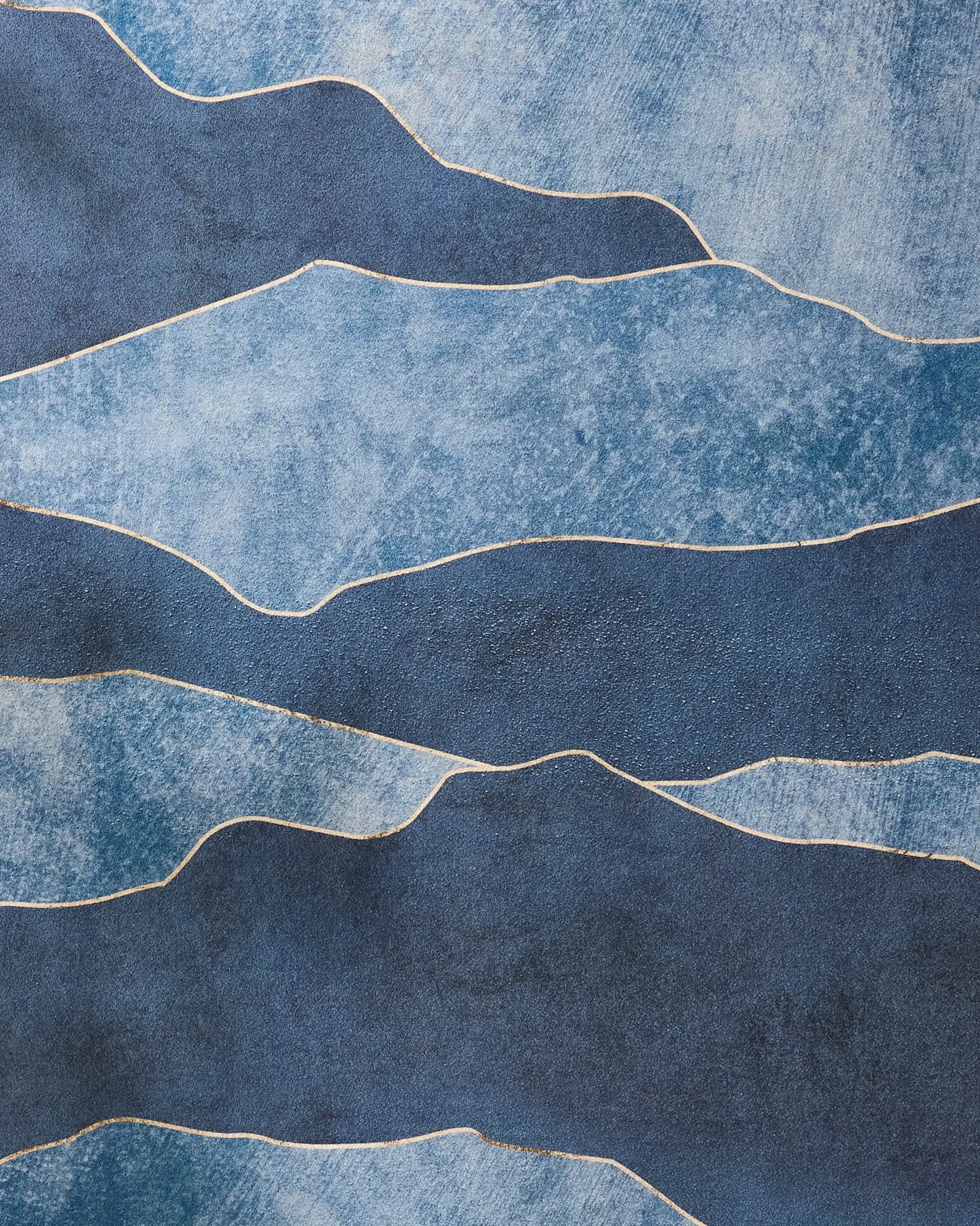 The GEOMETRY "Lined With Gold" features irregular, wavy blue bands with thin white lines, resembling a slip-resistant yoga towel or flowing water, and has a rough, painterly texture.