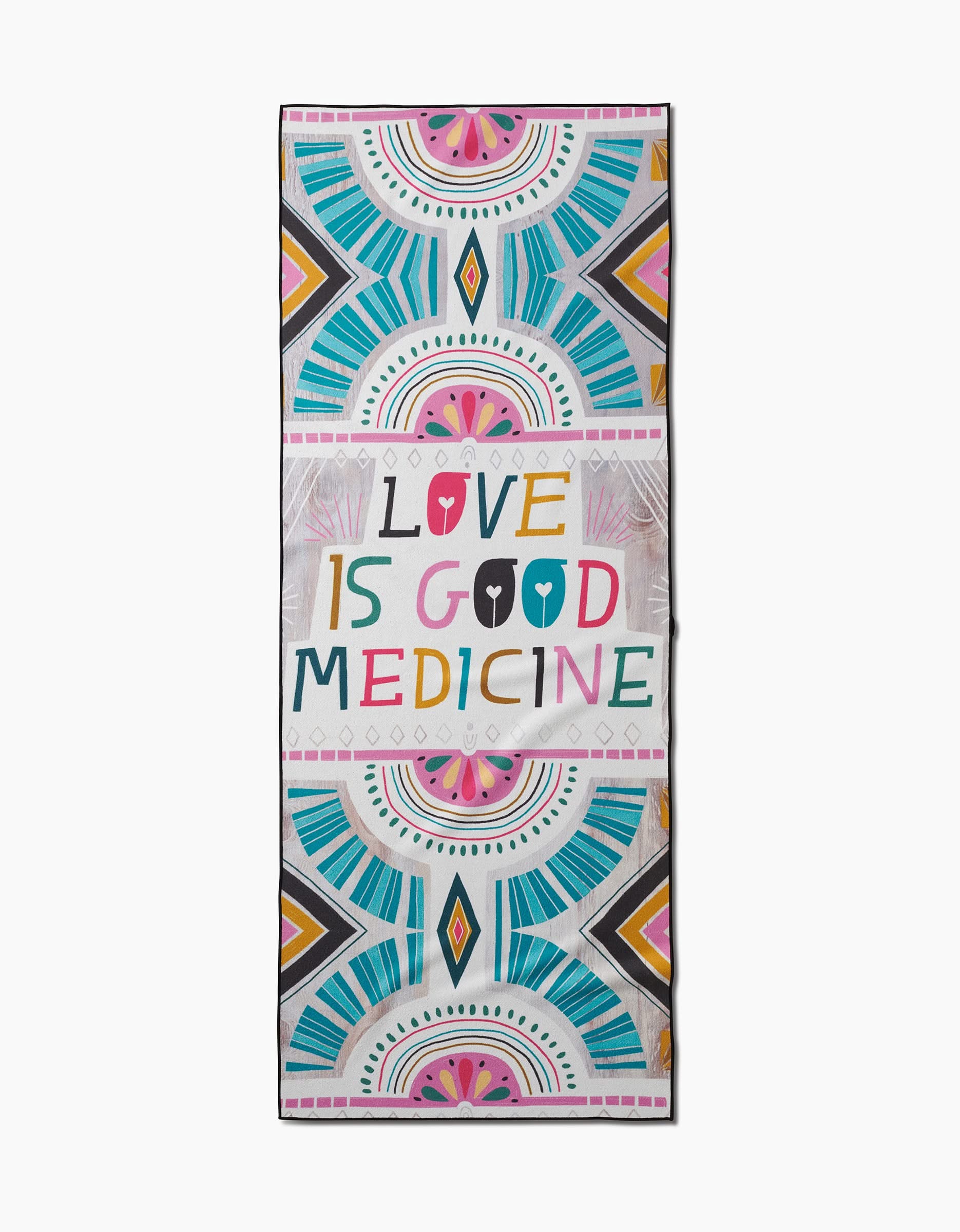 The Jessica Swift Love is Good Medicine yoga towel is a colorful, rectangular non-slip towel with blue, pink, yellow, and orange geometric patterns and bold multicolored LOVE IS GOOD MEDICINE at the center.