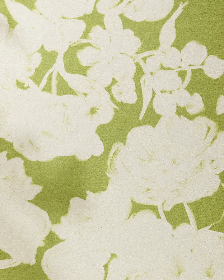 A close-up of GEOMETRY's Meadow Mist, a green recycled yoga towel with white floral patterns in soft, abstract outlines of flowers and leaves.