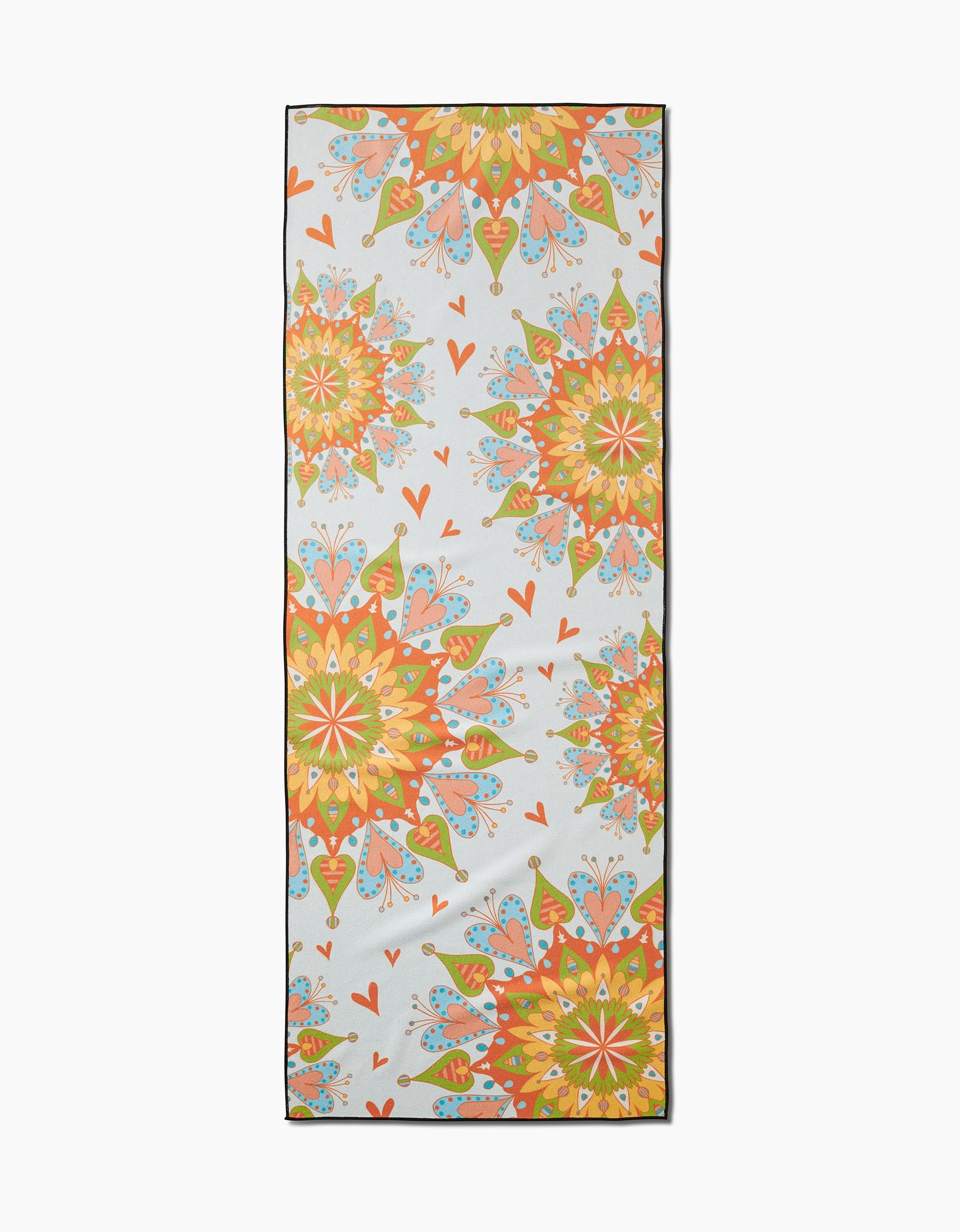 The Mindful Mandalas yoga mat by Mindfulnice features a light background with colorful symmetrical mandala patterns and red hearts, and pairs perfectly with a silicone grip yoga towel for added stability during practice.