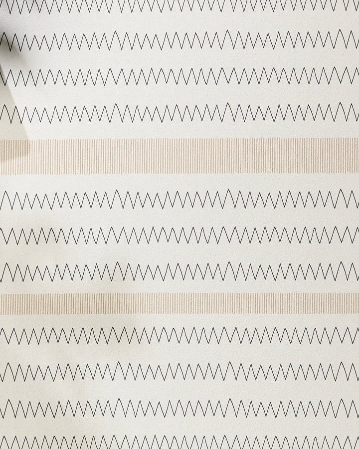 The Mod Zig Zag by Coit Creative features alternating rows of black zigzag lines and light beige vertical stripes on a white background, reminiscent of a recycled yoga towel. A shadow is visible in the top left corner.