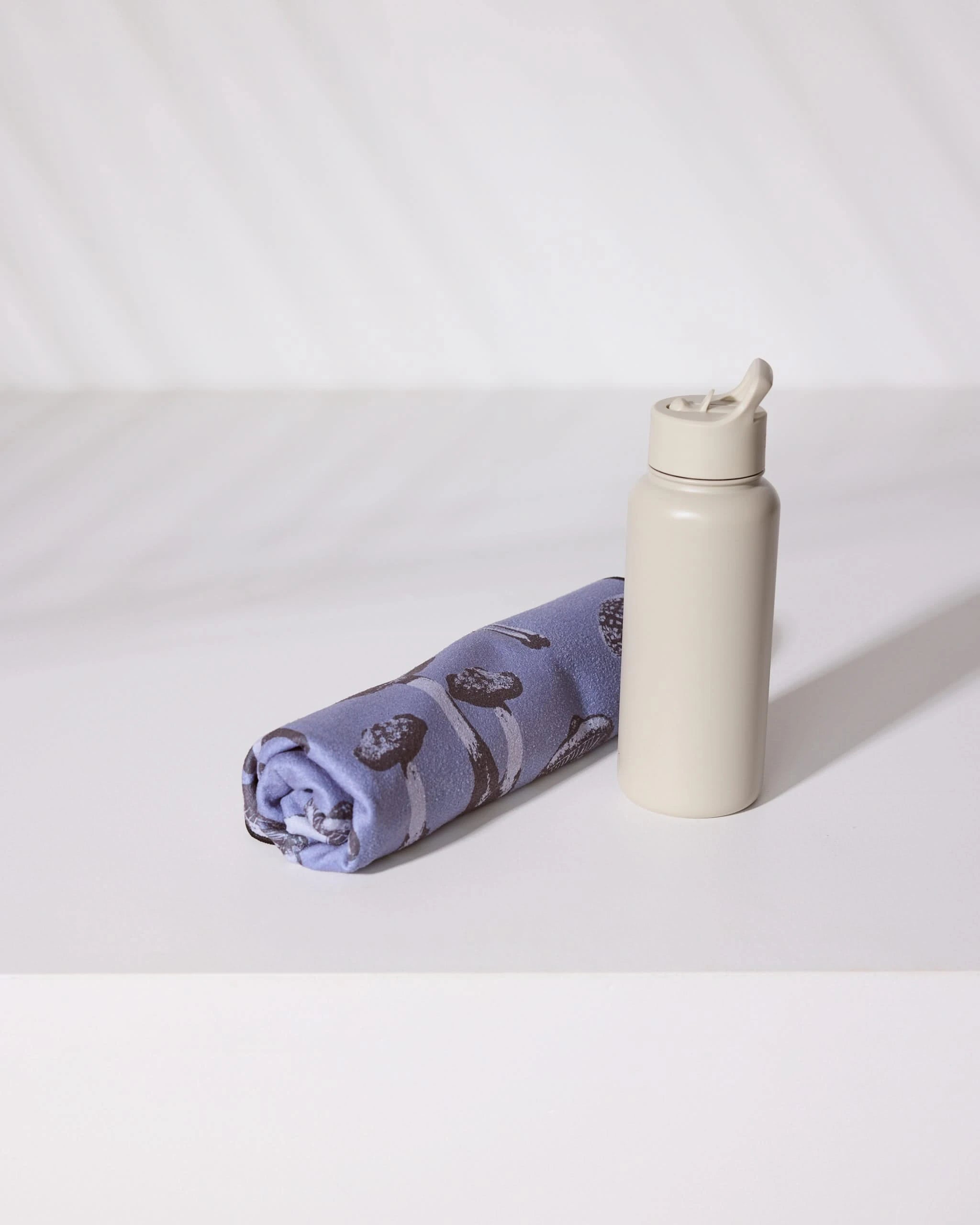 A Moody Autumn Mushrooms bottle and a non-slip yoga towel by Geometry.