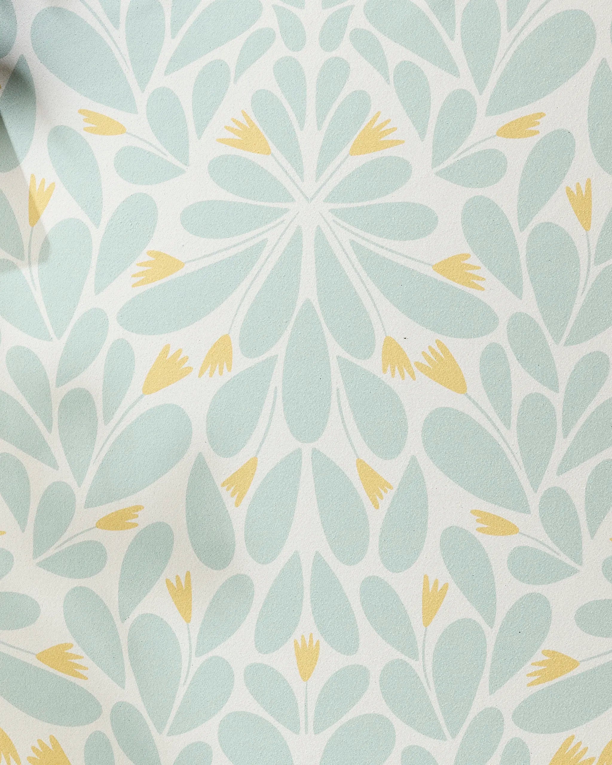 The Mustard Pinwheel yoga towel by Rebecca Woolbright features a light blue and yellow floral pinwheel design on a non-slip surface, adding elegance and decorative flair to your practice.