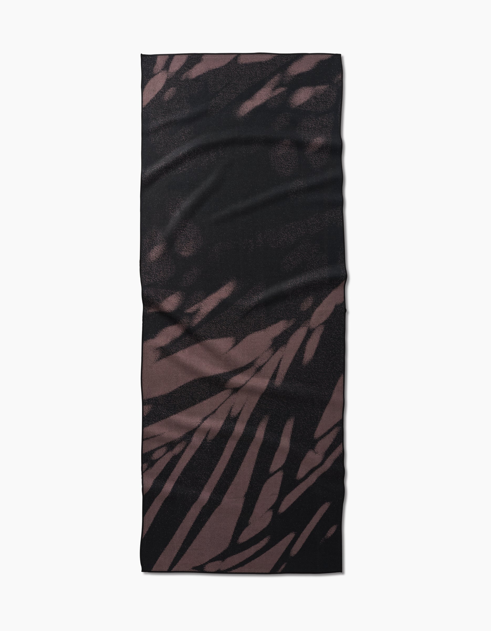 The GEOMETRY Palm Shadow is a rectangular yoga towel crafted from recycled materials, featuring an abstract streaked pattern in dark brown and black, displayed flat on a white background.