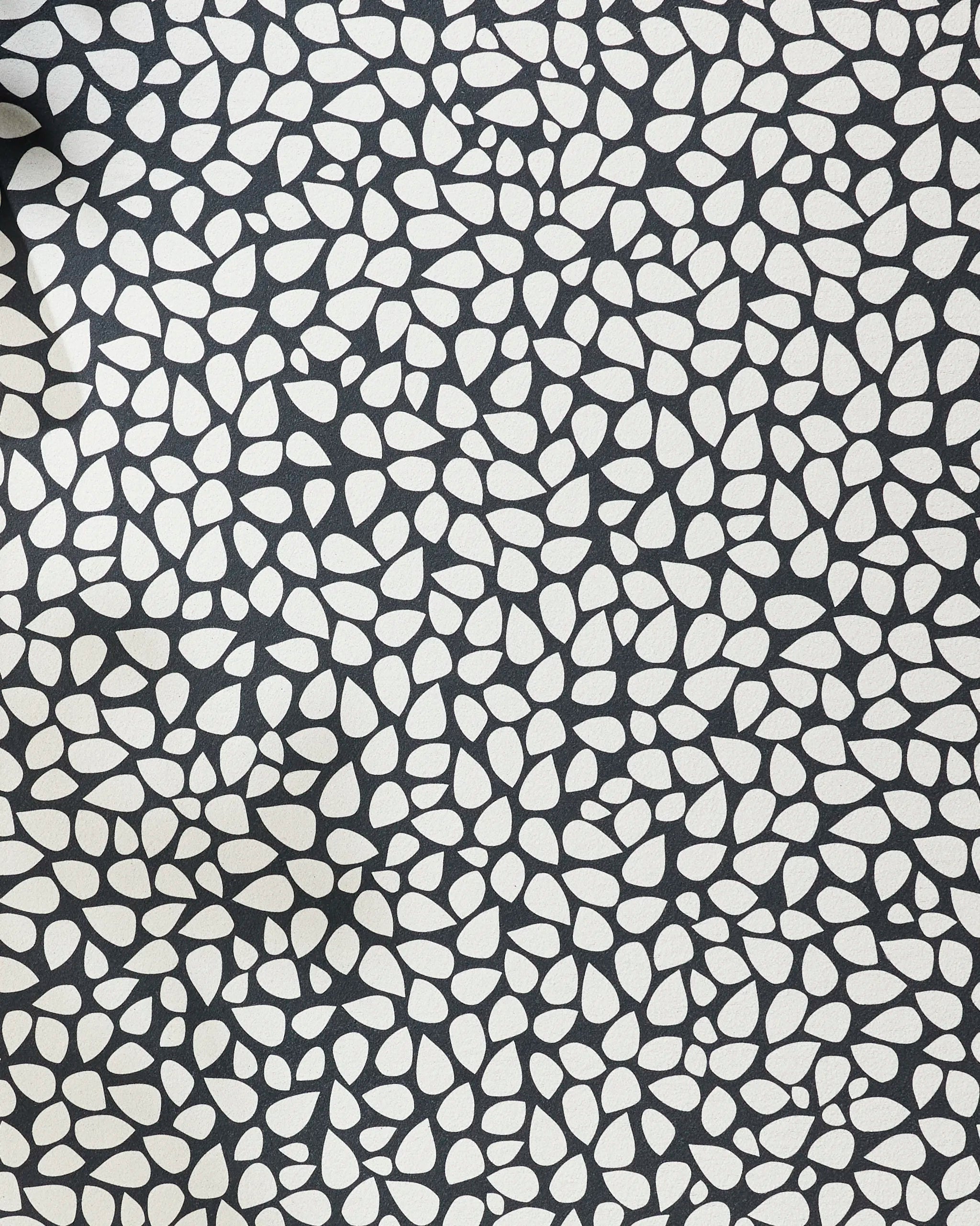 The Pebbles yoga towel by Marina Solodka features an abstract pattern of white pebble shapes on black, offering stylish texture and a dense design for enhanced grip and non-slip performance during your yoga practice.