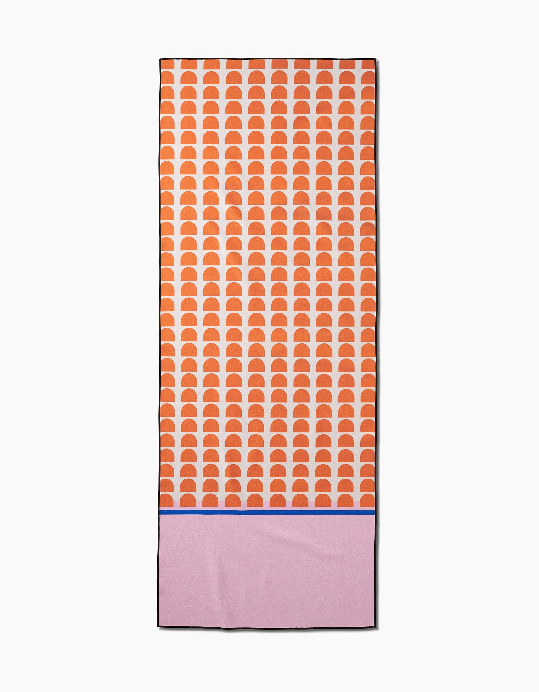 The Pink Illusion yoga towel by Happy Hemera is rectangular, made from recycled materials, and features orange-white semicircles on the top two-thirds plus a solid pink bottom with a thin blue line.
