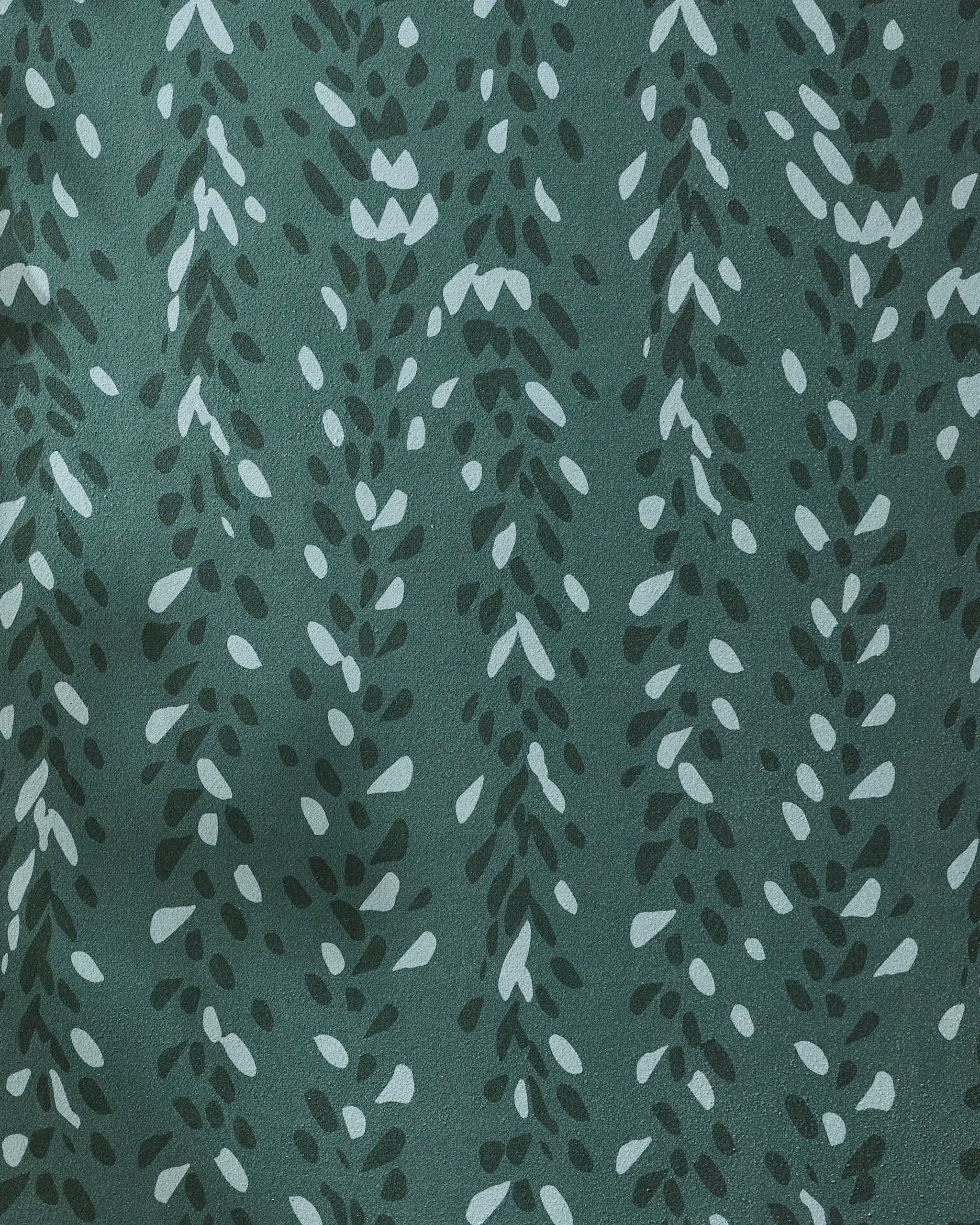 A close-up of Pose by GEOMETRY shows dark green recycled yoga towel fabric, patterned with light green and white leaf-like shapes in vertical, vine-like rows.