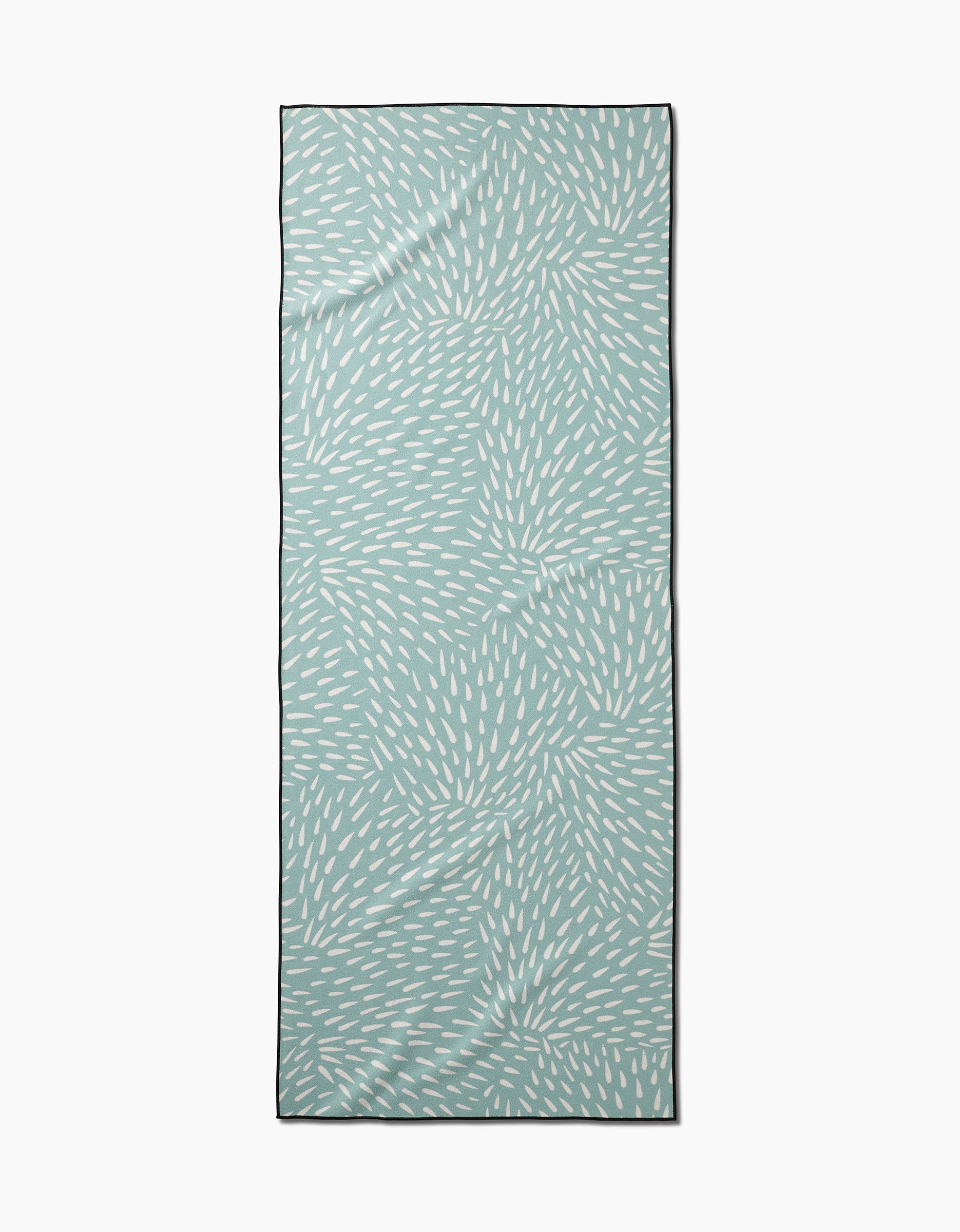 The Rebecca Woolbright Quill Blue yoga towel is rectangular and light blue, featuring scattered white ovals in a dynamic swirling design. Made from recycled materials, it has a thin dark border and appears on a plain white background.