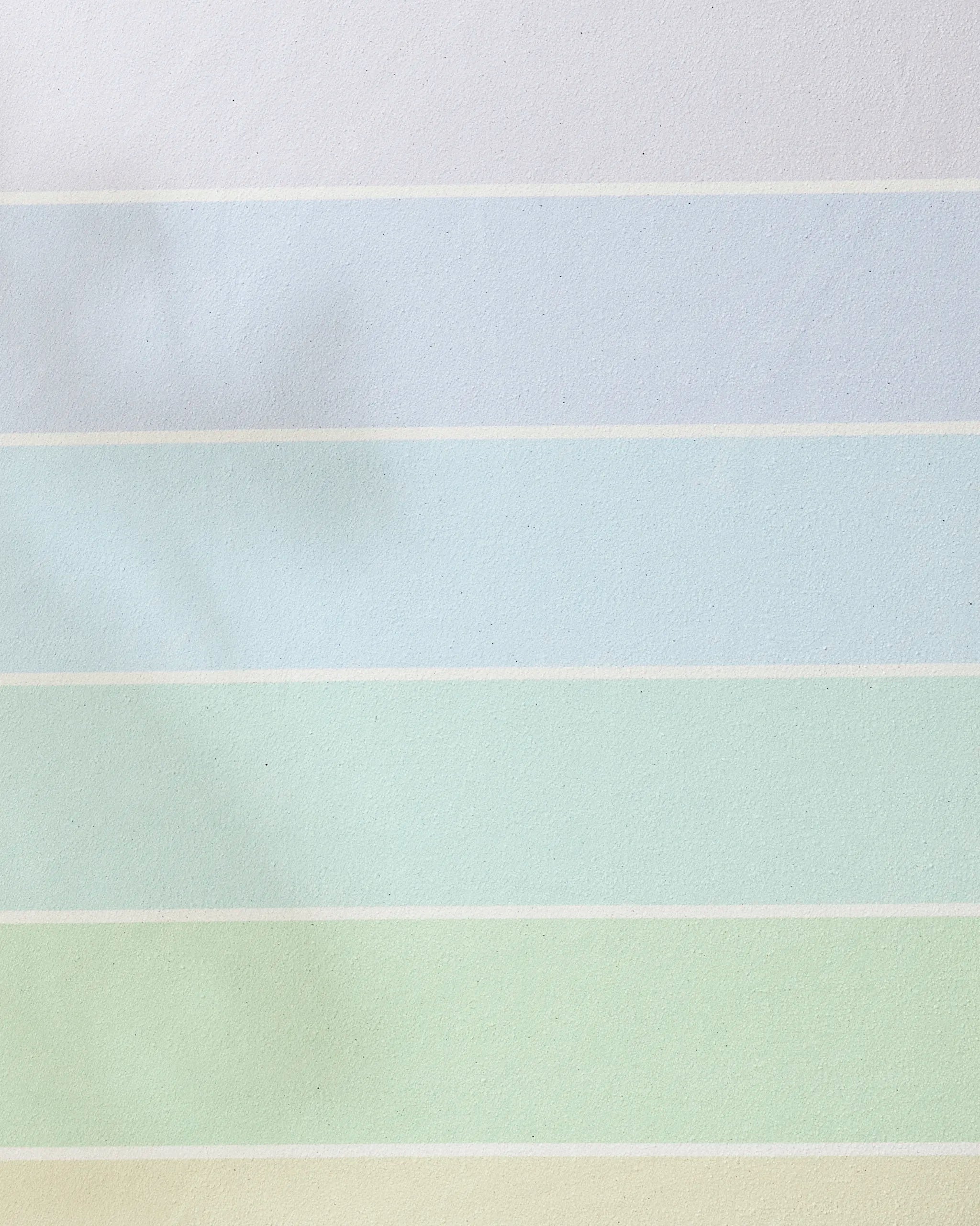 The GEOMETRY Rainbow Pastel recycled yoga towel features wide horizontal stripes in white, blue, green, and yellow for a calming, stylish look—perfect for an eco-friendly, non-slip yoga practice.