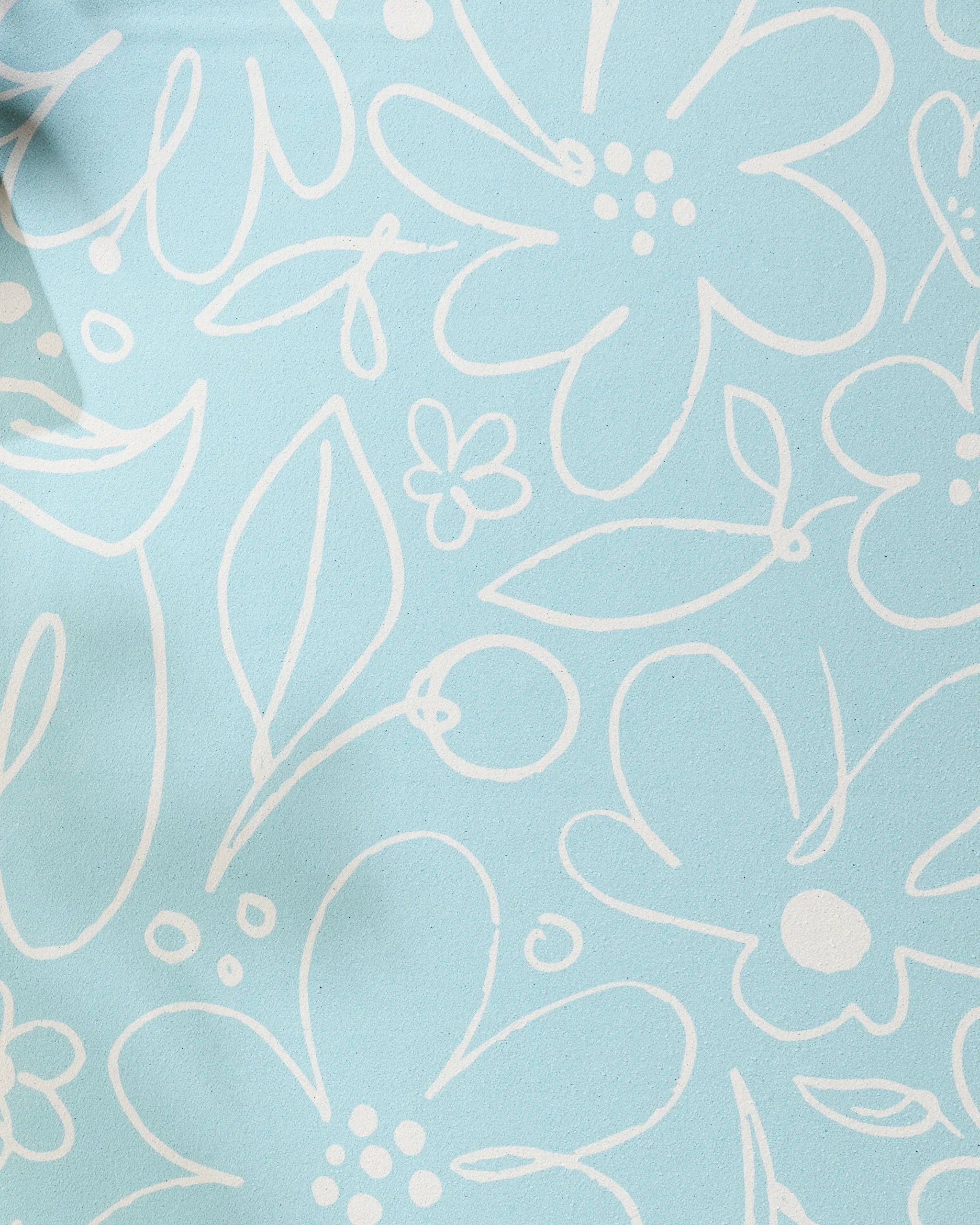 River Blossom by Sara Mari features a light blue background with a white, hand-drawn floral pattern—a playful, sketch-like design that brings charm and style to any recycled yoga towel.