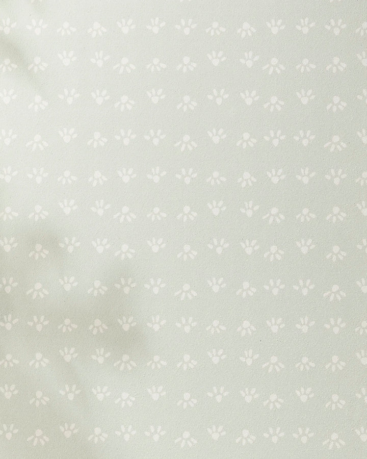 Sun Bursts by Anee Shah features a light green background with evenly spaced small white paw prints and subtle left-side shadows—ideal for a recycled yoga towel.