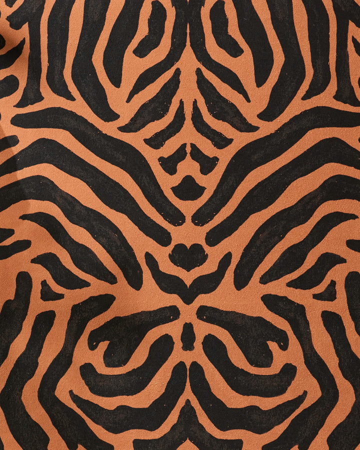 Close-up of the GEOMETRY Tiger yoga towel features a black and orange tiger stripe pattern on a textured, slip-resistant surface, highlighting its symmetrical, abstract design.