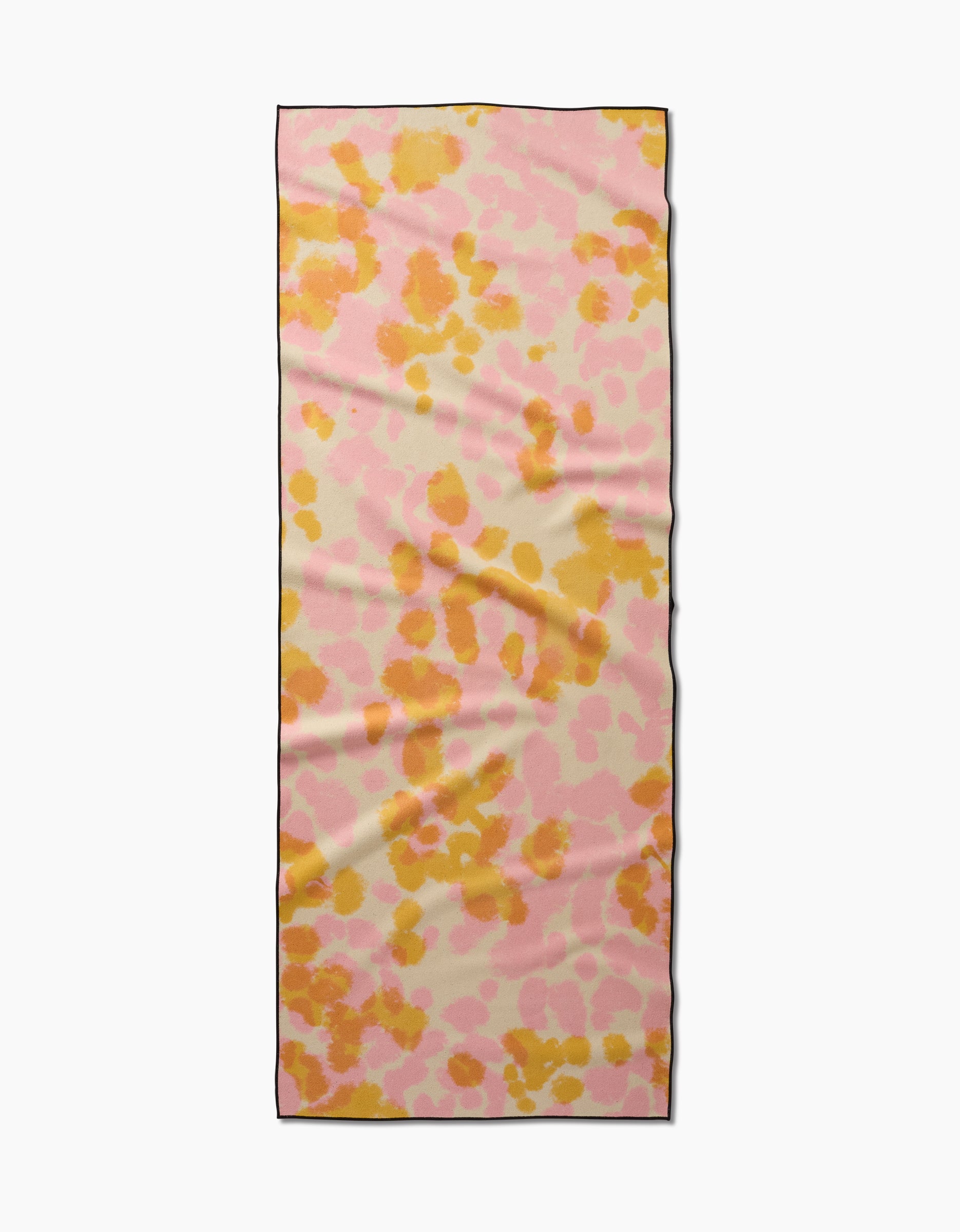 The GEOMETRY Whimsy yoga towel features irregular pink and orange spots on a cream background, is made from recycled materials, and is shown flat with slight wrinkles.