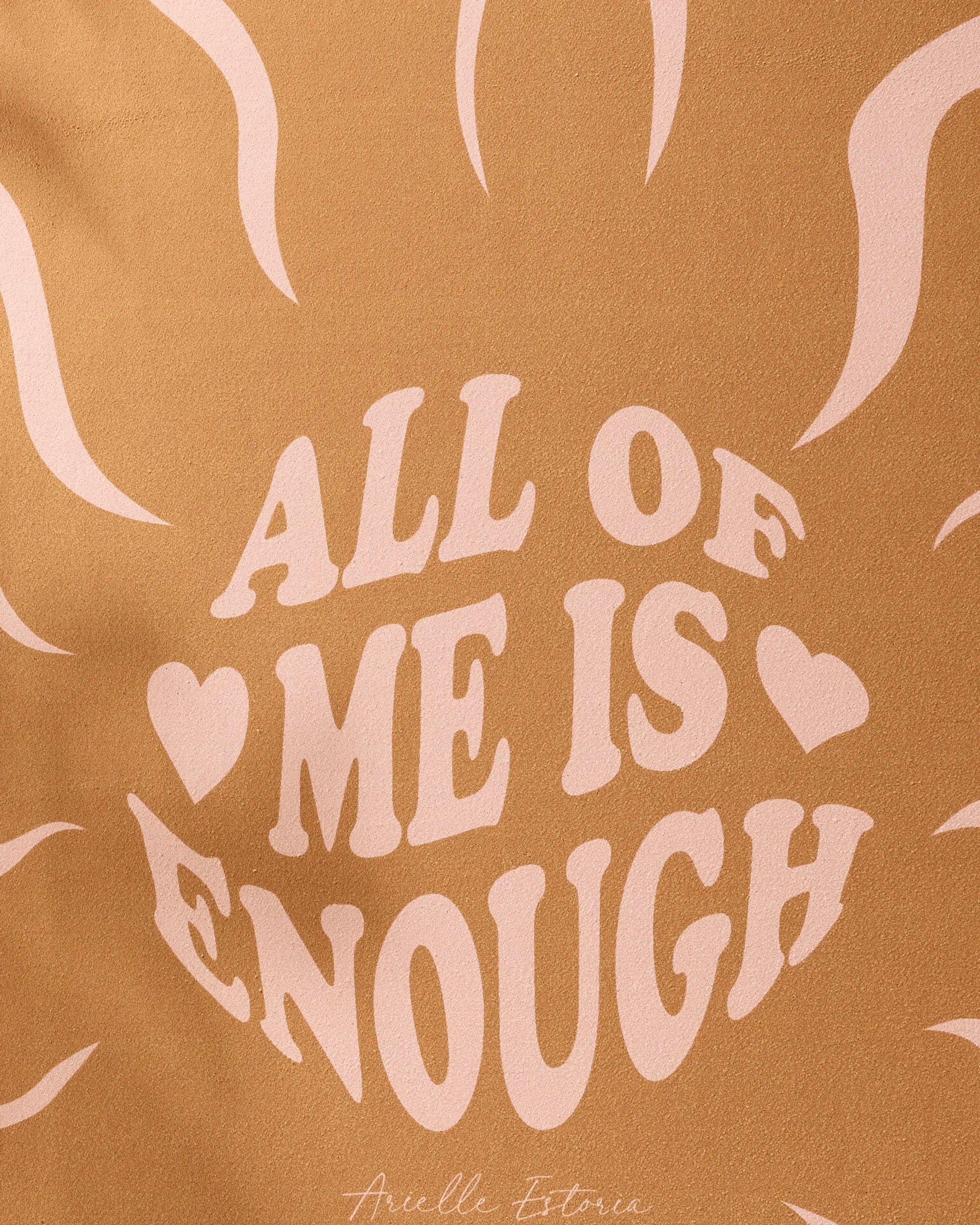 Featuring a tan background with light pink sun rays and “YOU ARE ENOUGH” in bold, retro lettering with two hearts, this Arielle Estoria recycled yoga towel inspires confidence every time you practice.