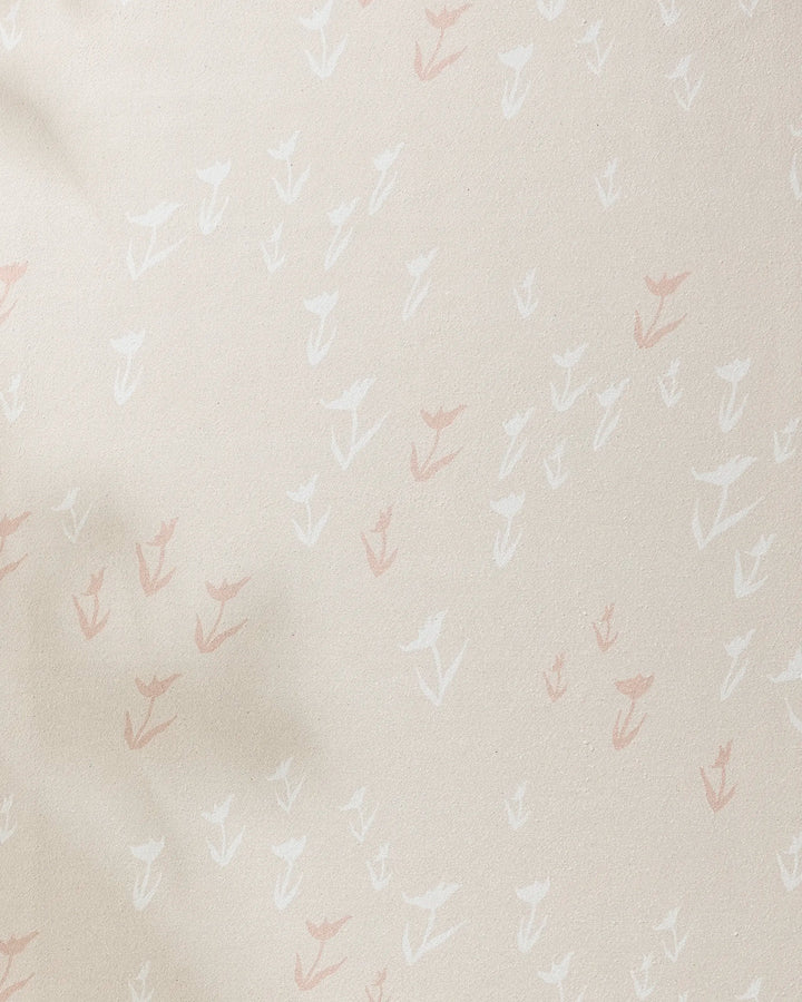 The Aubrey Fairchild "You Grow Girl" yoga towel is beige and slip-resistant, featuring a subtle pattern of small hand-drawn white and light pink flowers scattered across its surface.