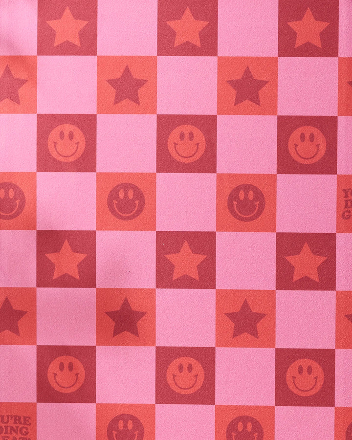 The "You're Doing Great" yoga towel by Quotes by Christie features a pink and red checkerboard pattern with red stars, smiley faces, plain reds, and bold red text on non-slip fabric.