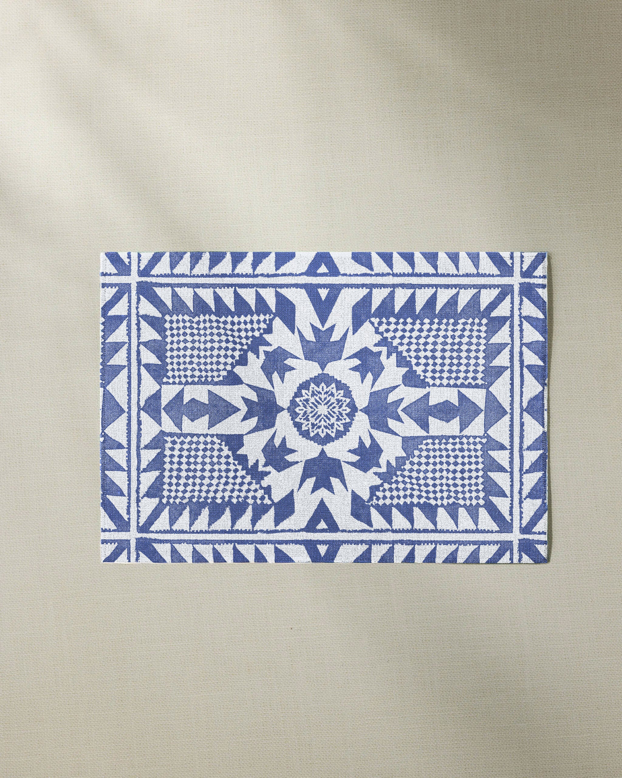 The Geometry Bluebird rectangular table mat features intricate blue geometric and floral patterns on a white background, adding eco-friendly style to your space.